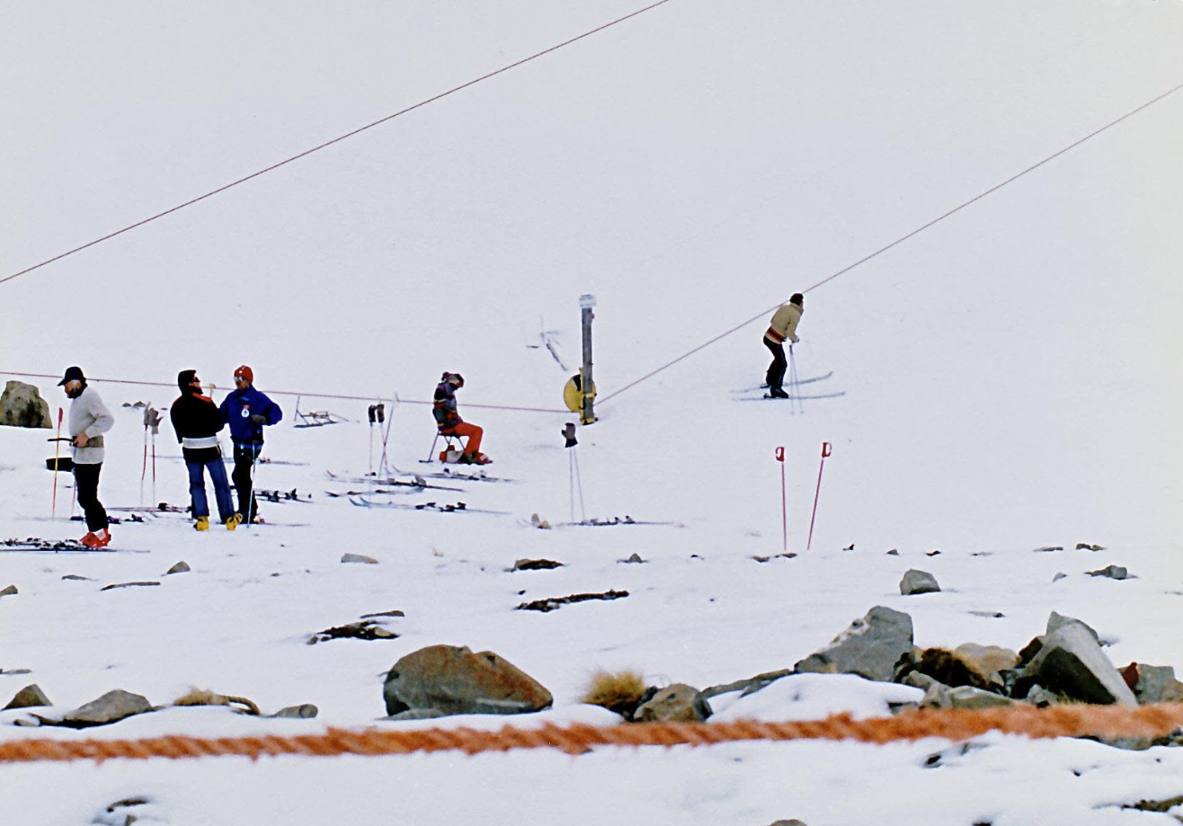 Members queuing for the rope tow, with one skier getting on partway up the slope